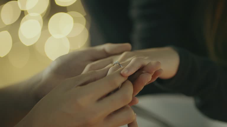 Man wears the ring on the finger of his girlfriend