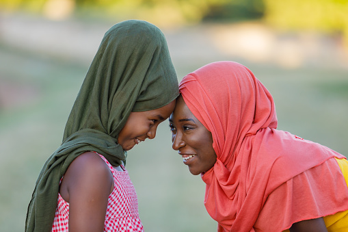 Mother and Daughter of Muslim Ethnicity With Hijabs are Sharing Sweetest Emotions Together, Outside in the Park and Hugging.