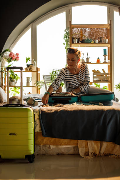 istock Woman packing a suitcase for a vacation 1324826341