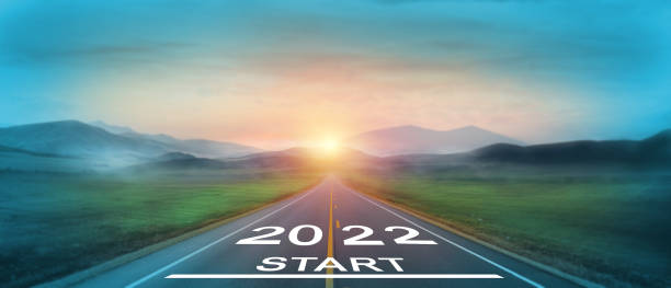 new year 2022 or start straight concept. word 2022 written on the road in the middle of asphalt road at sunset. concept of planning and challenge, business strategy, opportunity and new life change - 2021 圖片 個照片及圖片檔