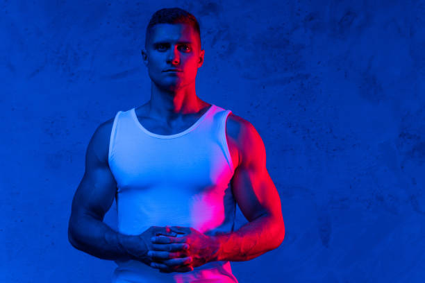 istock Handsome and confident bodybuilder posing in colorful light 1324830893