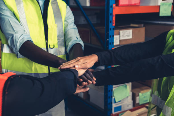 istock Factory workers stacking hands together in warehouse or storehouse 1324830985