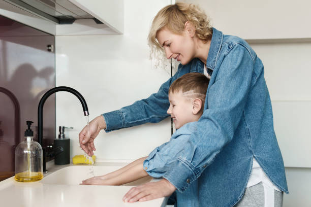 istock Young mother helping to her son during hand washing routine 1324831823