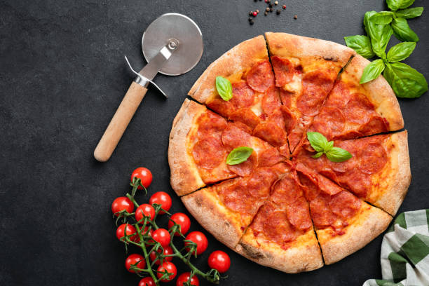 istock Delicious hot pepperoni pizza on black concrete background 1324832060