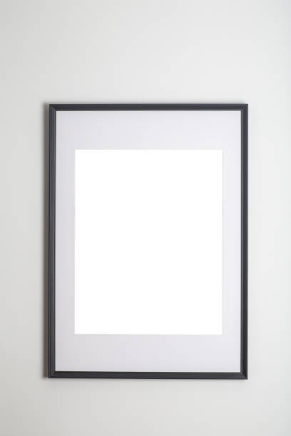 istock Mock up poster frame in interior white wall. White frame for poster or photo image on clean wall in home room or office interior 1324834008