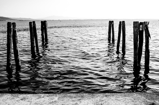 Poles in the water at the pier of San Feliciano