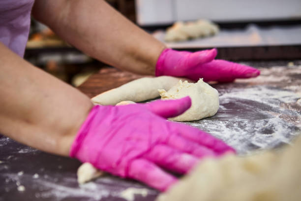 istock Bakers hands form dough for baking bread and put it into oven-tray at the manufacturing 1324834684