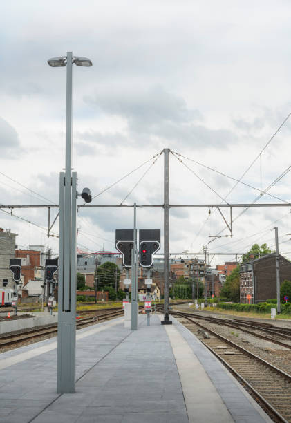 Empty platform at the station. Red signal semaphore lamp post and reproducers