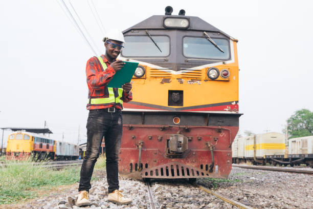 istock African man engineer looking report of Train Timetables for control a the train on railway 1324836608