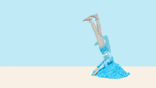 istock Male doll hiding his head in sand escaping from problems. Copy space. Minimal concept. 1324838687