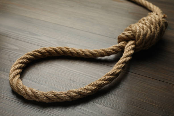 istock Rope noose on wooden table, closeup view 1324839634