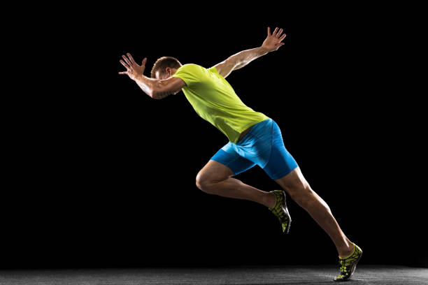 The runner's start. Caucasian professional male athlete, runner running isolated on black studio background. Muscular man. Concept of action, motion, youth, healthy lifestyle. Copyspace for ad.