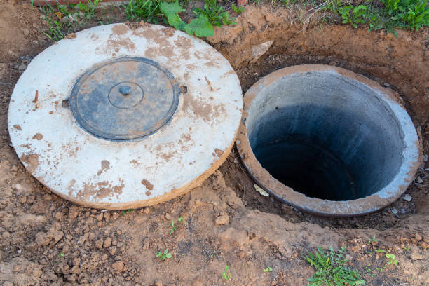 istock a well made of concrete rings and a cover with a plastic hatch. Home drainage system construction. Sanitary septic tank 1324842575