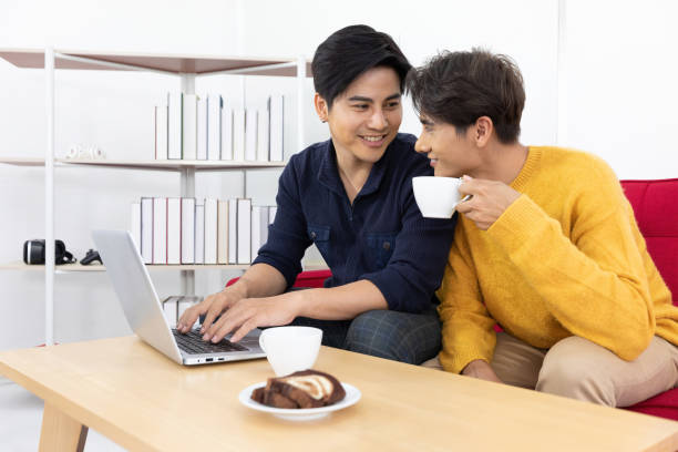 istock asian two men homosexual or gay couples, holding cups of coffee and working or using computer laptop together, LGBT concept 1324843733