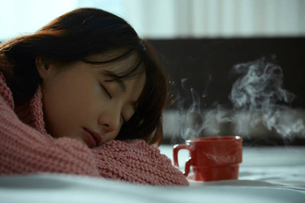 A young Asian woman is relaxing on the bed Day time oversleeping stock pictures, royalty-free photos & images