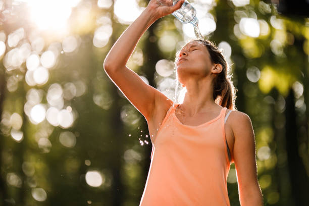 istock Tired female athlete refreshing herself with water in nature. 1324844419
