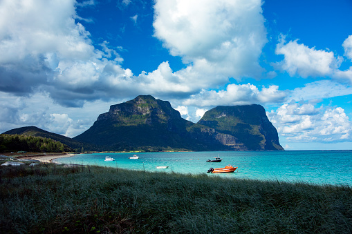 Lord Howe Island is an irregularly crescent-shaped volcanic remnant in the Tasman Sea between Australia and New Zealand, 600 km (320 nmi) directly east of mainland Port Macquarie, 780 km (420 nmi) northeast of Sydney, and about 900 km (490 nmi) southwest of Norfolk Island. It is about 10 km (6.2 mi) long and between 0.3 and 2.0 km (0.19 and 1.24 mi) wide with an area of 14.55 km2 (3,600 acres), though just 3.98 km2 (980 acres) of that comprise the low-lying developed part of the island