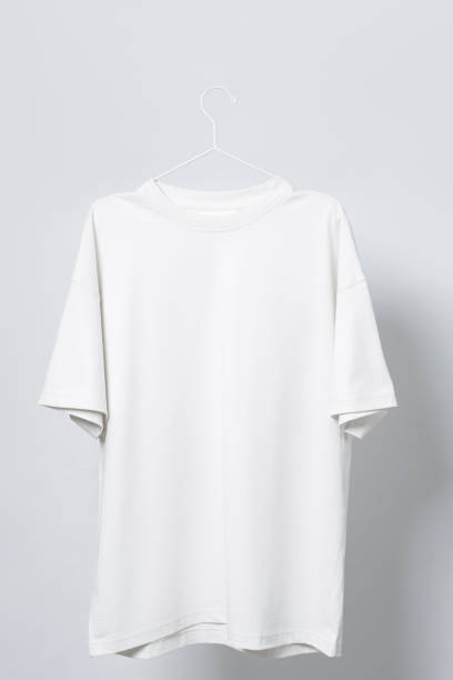 istock Blank white t-shirt hanging on a hanger against gray background 1324846282