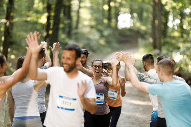 szczęśliwi maratończycy witając grupę sportowców na mecie. - marathon finish line finishing the end zdjęcia i obrazy z banku zdjęć