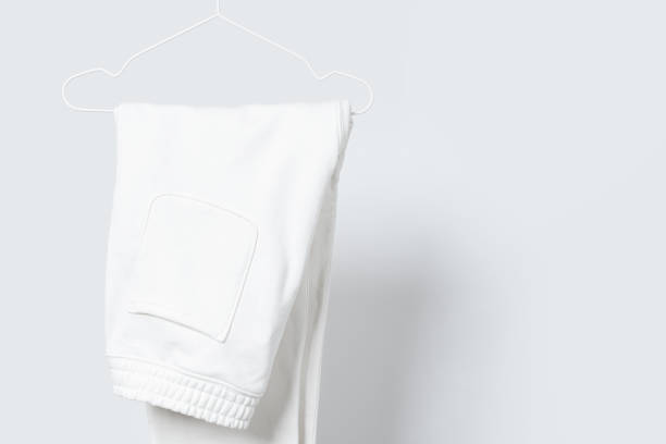 istock Blank white sweatpants hanging on a hanger against gray background 1324846909