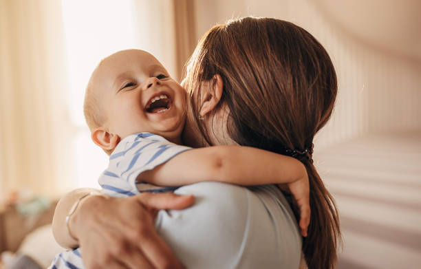 mutter umarmt ihren kleinen sohn - baby stock-fotos und bilder