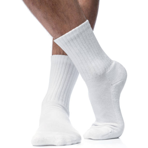 istock Male feet with white cotton socks on white background 1324847144