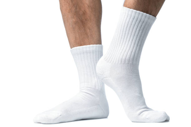 istock Male feet with white cotton socks on white background 1324847156