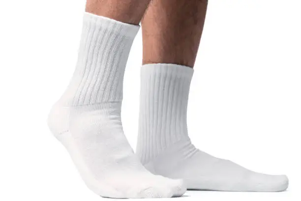 Photo of Male feet with white cotton socks on white background