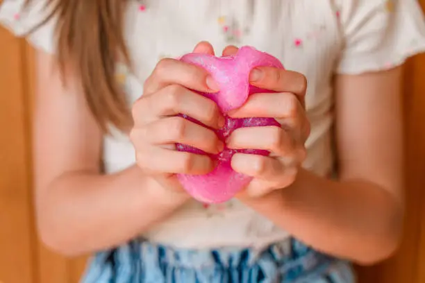 Photo of Little girl crumples in the hands of slime, children's toy, entertainment