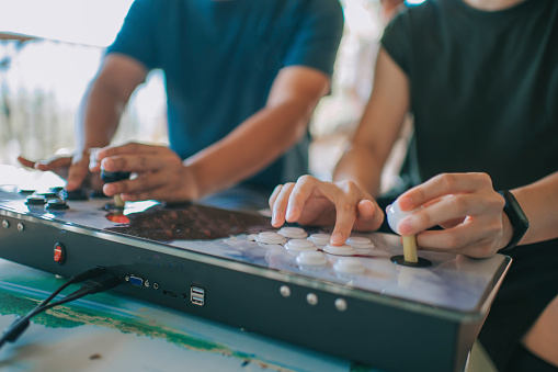 2 asian chinese male playing retro style video game