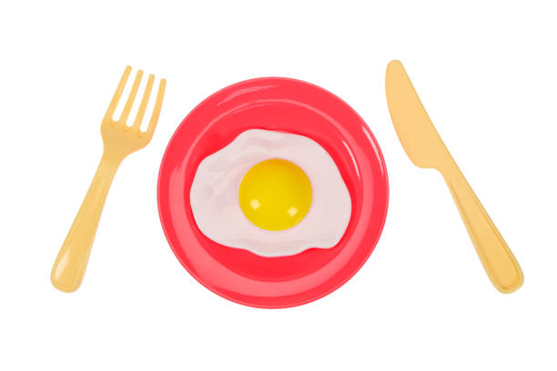 istock Fork, knife and fried eggs in a plate on a white background, isolated image 1324848578