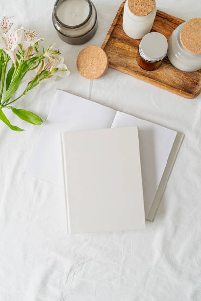 istock book, coffee and flowers top view on white bed. Mock up design 1324850397