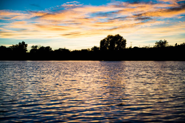 istock Sunset on a river, the vegetation is silhouetted against the horizon. 1324850444
