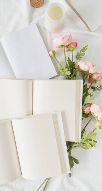 istock Opened books and flowers top view on white bed. Mock up design 1324850551