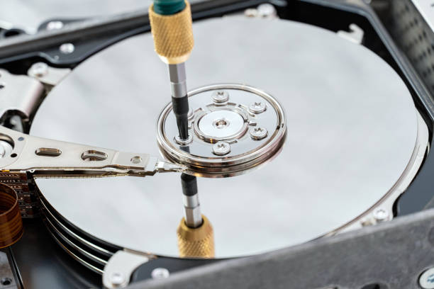istock hard disk drive disassembling process with screwdriver in information recovery, repair HDD service 1324851524