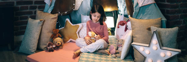 istock Girl playing with stuffed animals in a teepee 1324852200