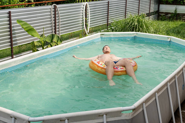 giovane nuoto su tubo gonfiabile nuoto in piscina - swimming tube inflatable circle foto e immagini stock