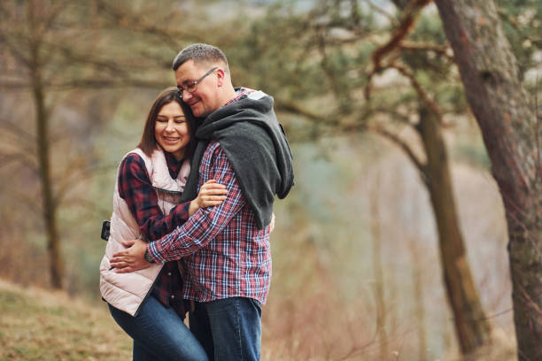 istock Happy mature couple standing and embracing each other outdoors in forest 1324855598