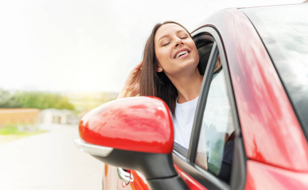 istock Beautiful young woman driving a car. 1324855811