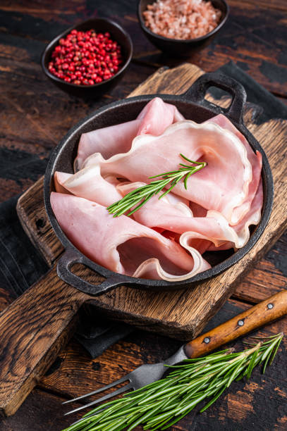 istock Prosciutto ham sliced in a pan. Dark wooden background. Top view 1324856058