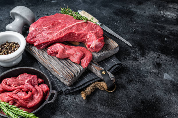 istock Beef fillet round cut Sliced on a butcher cutting board. Black background. Top view. Copy space 1324856406