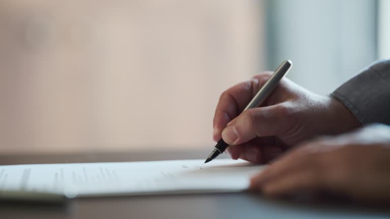 Businessman Signing Legal Paper In Office