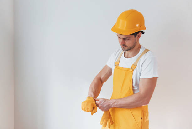 istock Handyman in yellow uniform preparing for work indoors. House renovation conception 1324857477