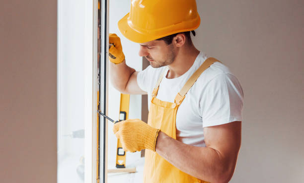 istock Handyman in yellow uniform installs new window. House renovation conception 1324857583