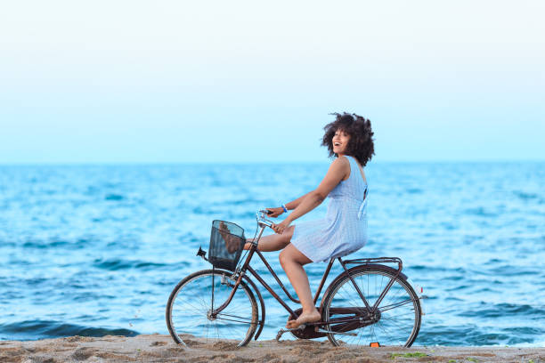 istock African Woman riding bicyle on sand 1324857604