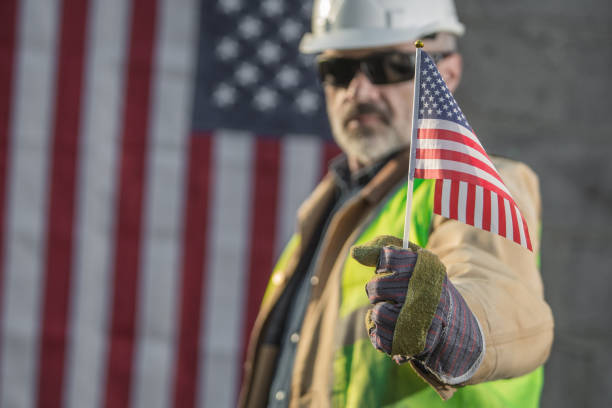 A serious worker man and american flag A serious worker man and american flag patriotic man stock pictures, royalty-free photos & images