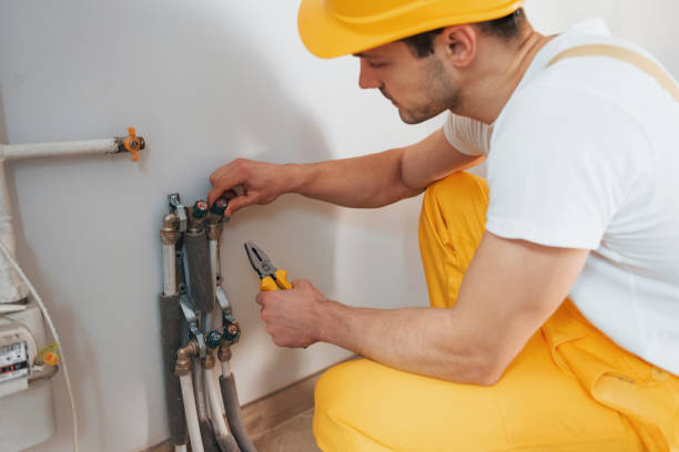 istock Handyman in yellow uniform works indoors. House renovation conception. Installing new device 1324860444