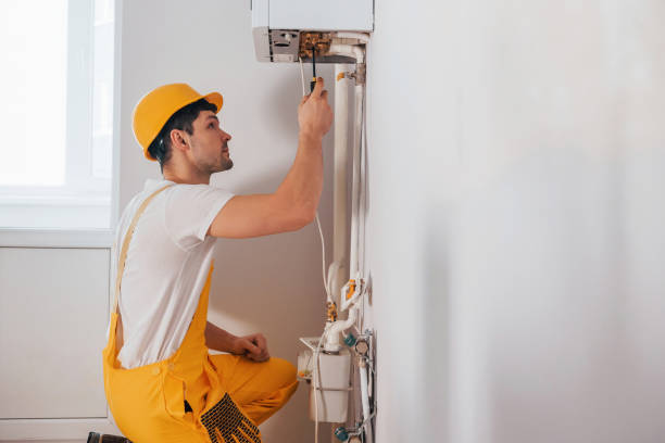 istock Handyman in yellow uniform works indoors. House renovation conception. Installing new device 1324860473