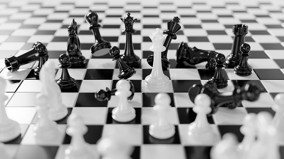 Battle on a chessboard. White chess pieces winning.