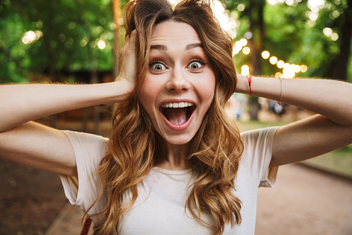 Close up of cheerful young girl screaming while standing at the park